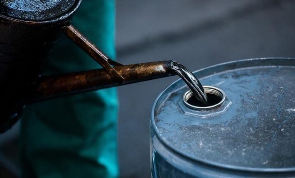 Pétrole brut versé dans un baril métallique, illustrant la chute du Brent à 62,33 $ le baril dans un marché marqué par un surplus d’environ 1,9 million de barils quotidiens.