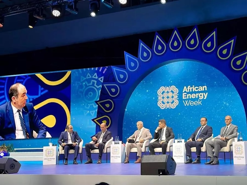 Panel de discussion à l'African Energy Week 2025 au Cap avec des dirigeants du secteur énergétique assis sur scène devant le logo de l'événement